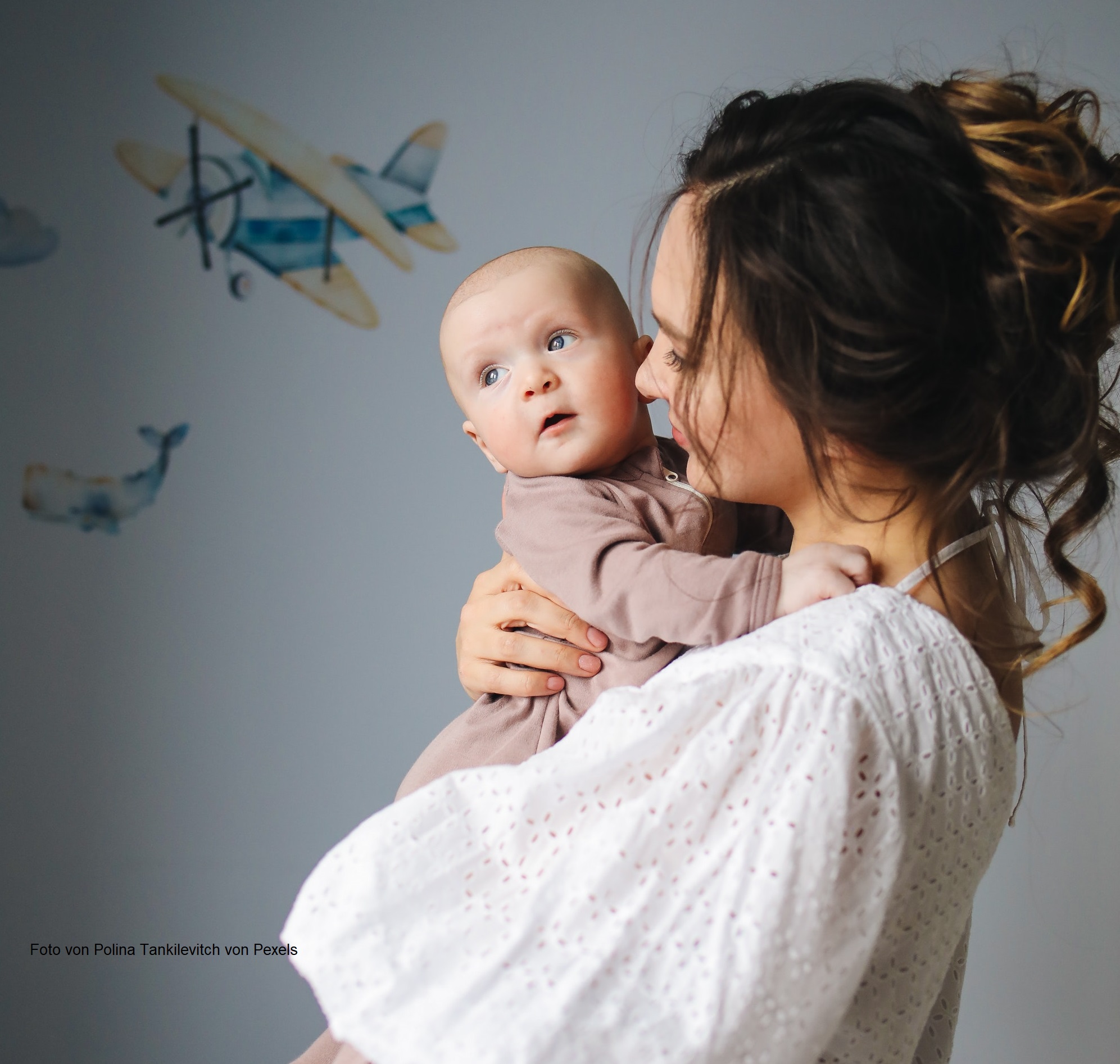 Baby wird auf Mamas Arm gehalten